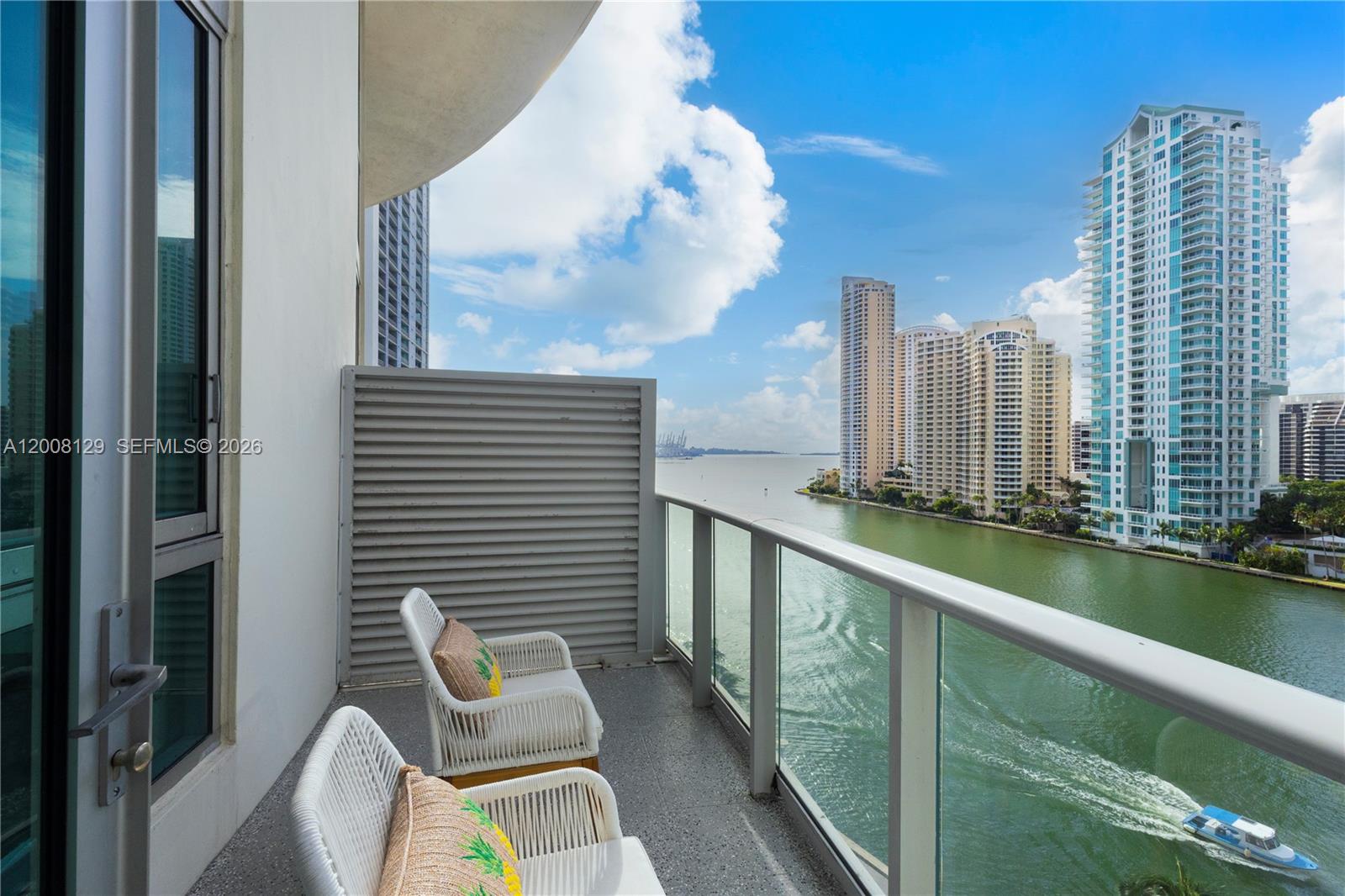 A balcony with two white chairs overlooks a river and city skyline — 300 S Biscayne Blvd # 1014, Miami FL 33131, MIAMI, FL