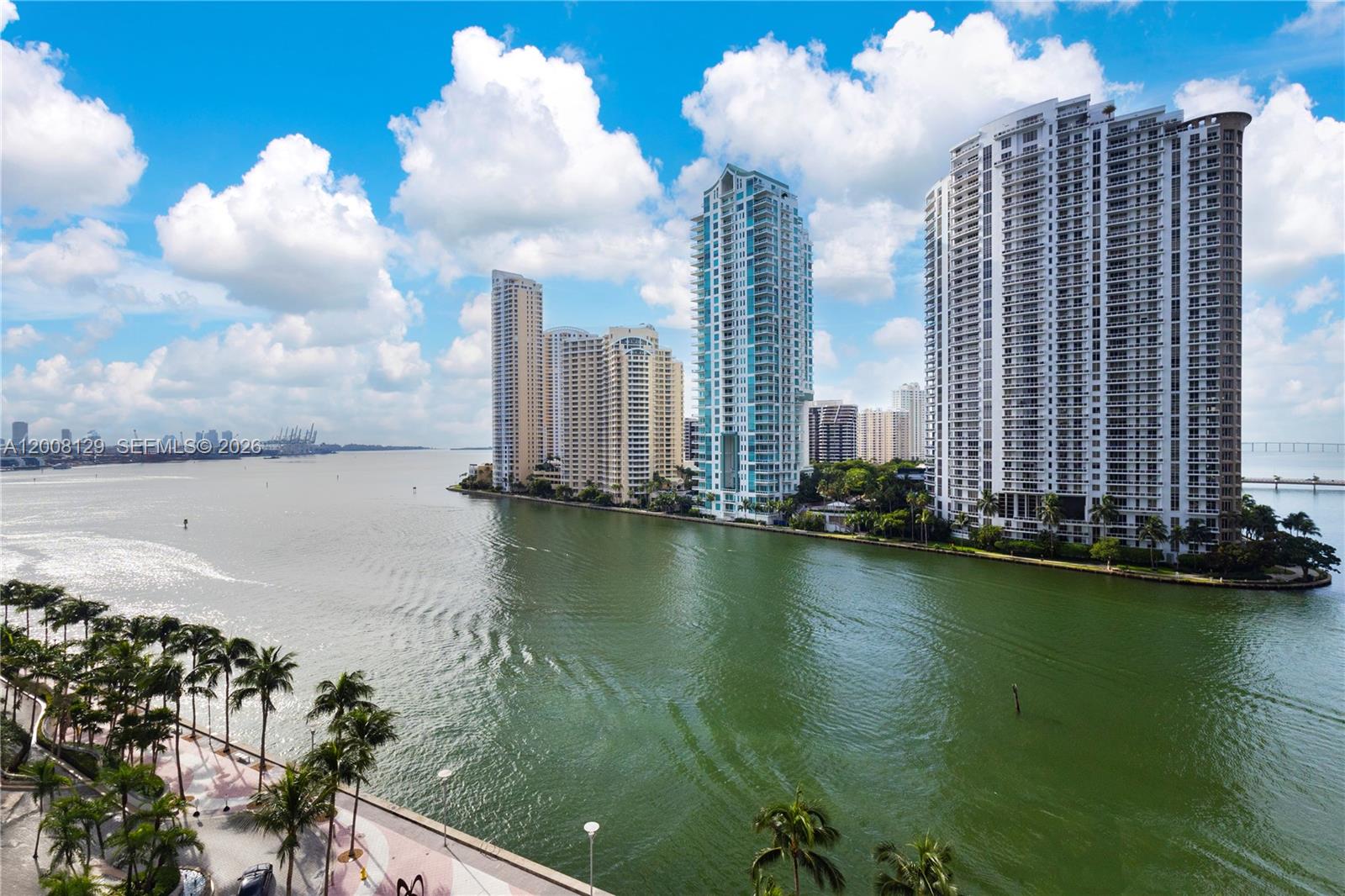 An elevated view of a waterfront area featuring several high-rise apartment buildings and palm trees — 300 S Biscayne Blvd # 1014, Miami FL 33131, MIAMI, FL