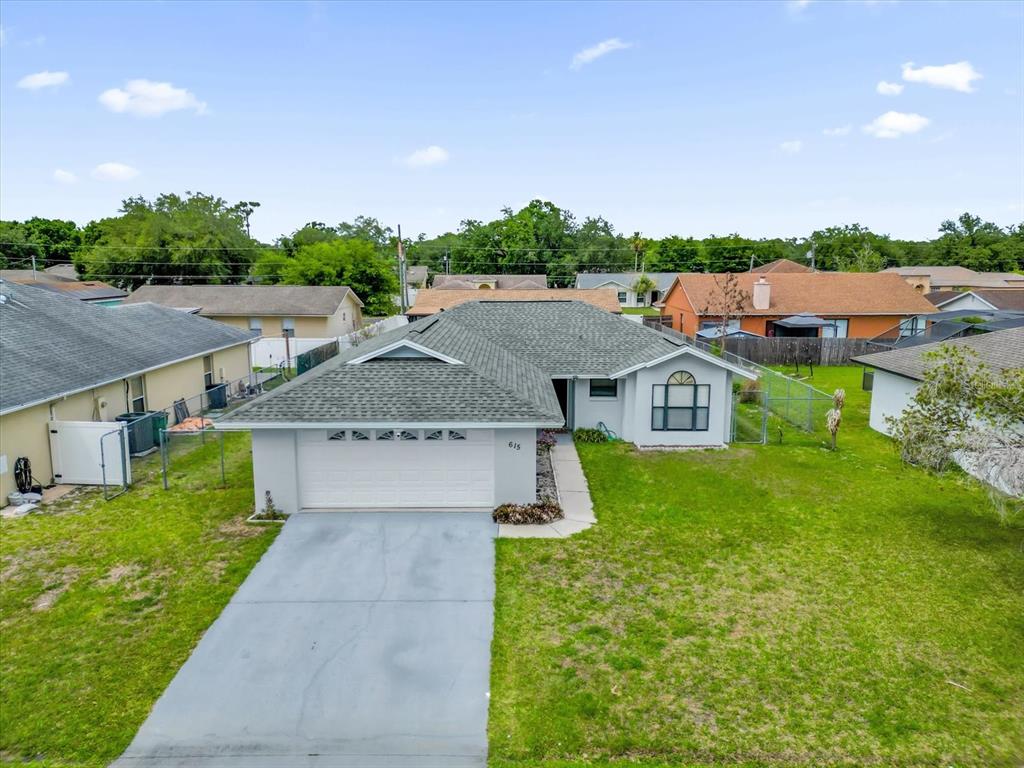 An aerial view of a single-story house with a gray roof and a concrete driveway — 615 MCKINLEY COURT, KISSIMMEE, FL