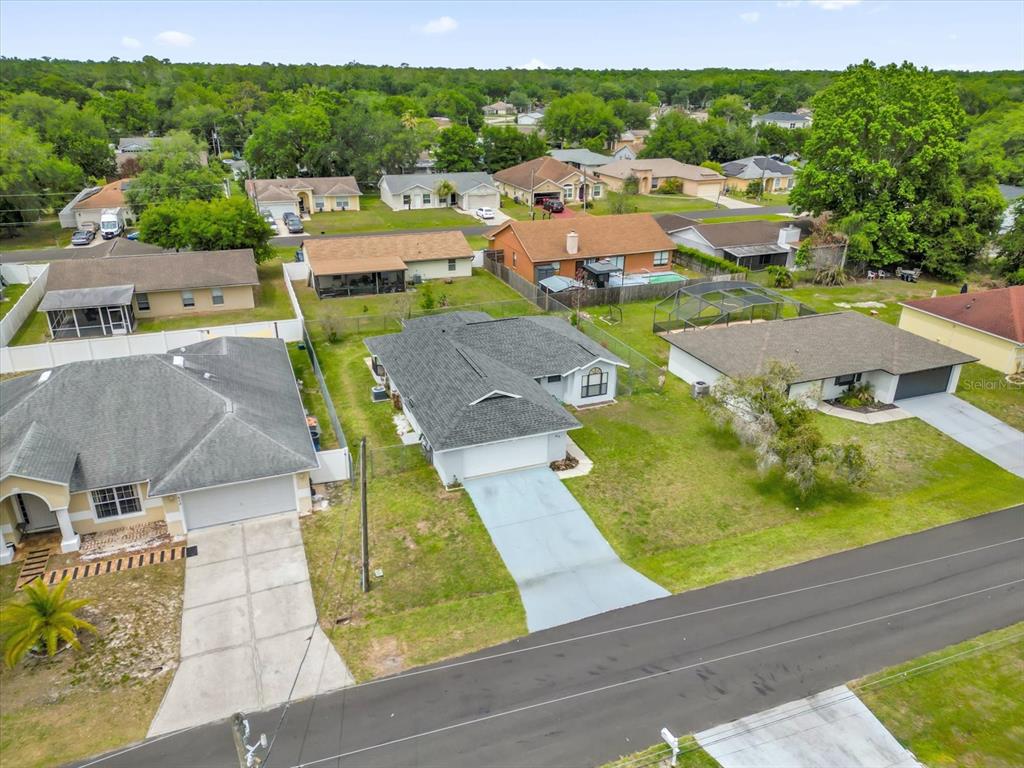 An aerial view shows a suburban neighborhood with several single-story houses and paved driveways — 615 MCKINLEY COURT, KISSIMMEE, FL