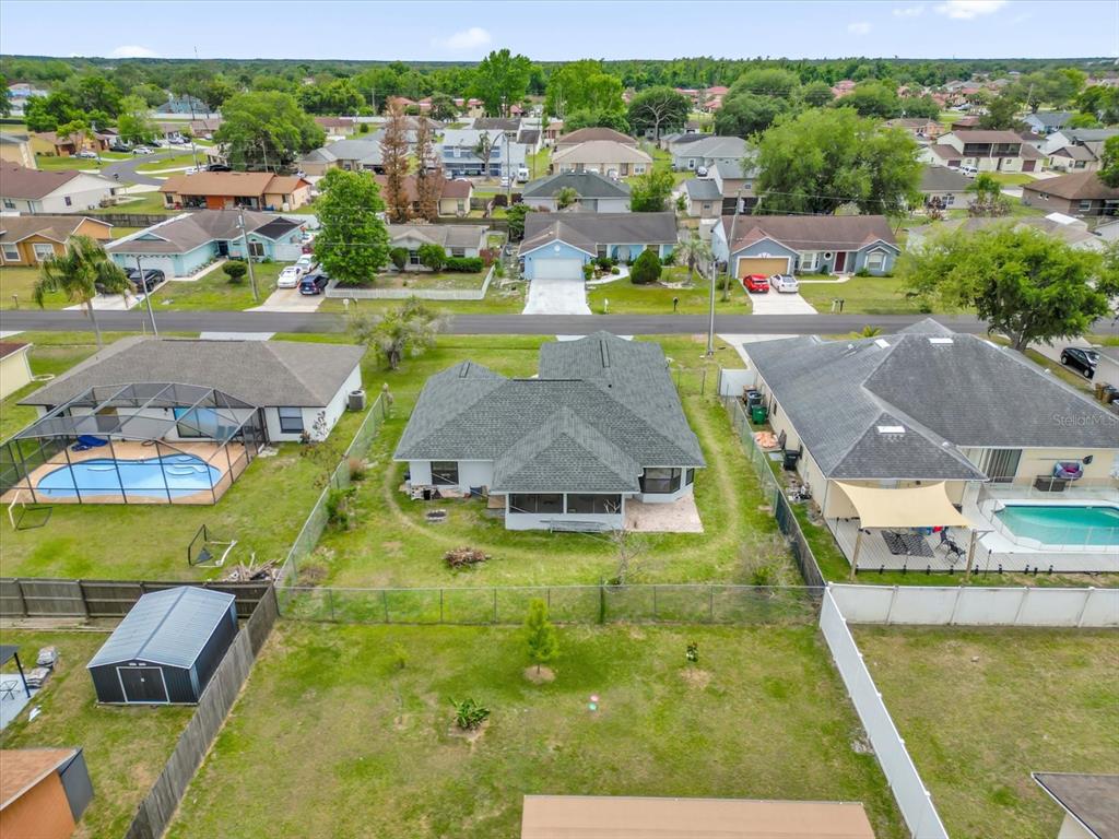An aerial view shows a residential backyard with a house, pool, and detached shed — 615 MCKINLEY COURT, KISSIMMEE, FL
