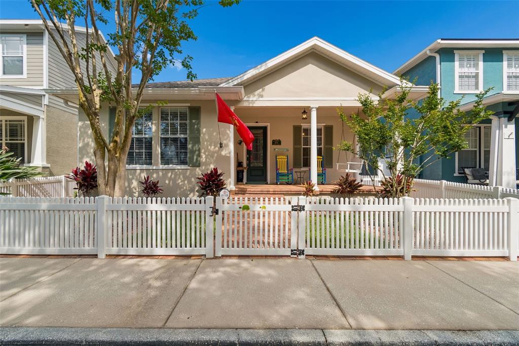 A front porch with a United States Marine Corps flag, two colorful chairs, and a swing — 3550 FERRELL STREET, NEW PORT RICHEY, FL