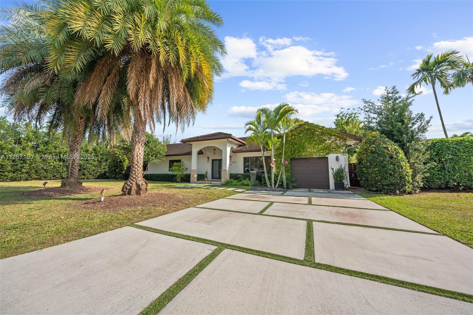 A single-story house features a concrete driveway with grass strips and mature palm trees — 6420 SW 63rd Ter, South Miami FL 33143, SOUTH MIAMI, FL
