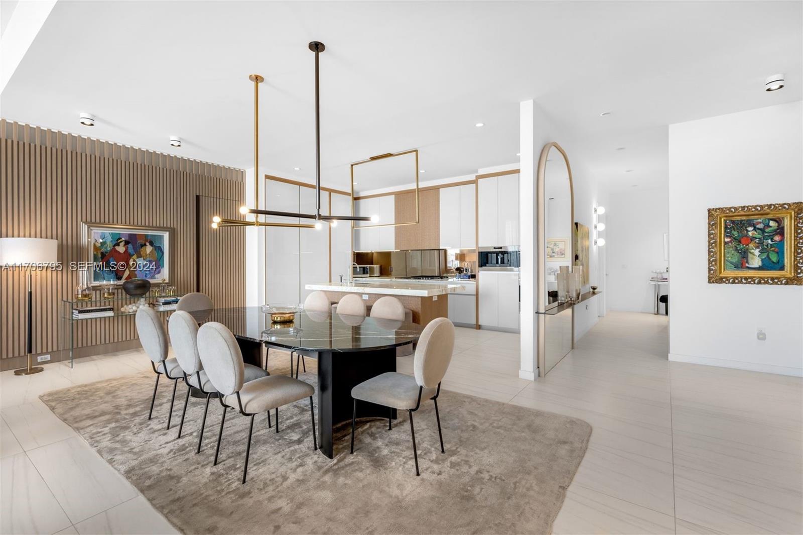 A modern dining area features a black marble table, upholstered chairs, and a slatted wood wall — 2811 S Bayshore Dr, Miami FL 33133, MIAMI, FL