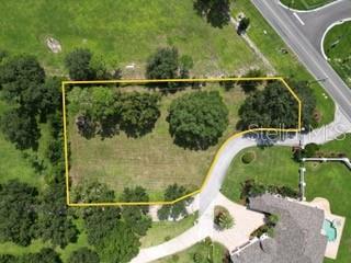 An aerial view shows a vacant, rectangular lot outlined in yellow near a paved driveway — 0 ELOISE LOOP ROAD, WINTER HAVEN, FL