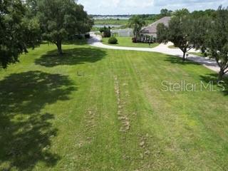 An aerial view of a grassy vacant lot with mature trees and a paved driveway — 0 ELOISE LOOP ROAD, WINTER HAVEN, FL