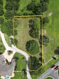 An aerial view shows a vacant, tree-lined residential lot outlined in yellow — 0 ELOISE LOOP ROAD, WINTER HAVEN, FL