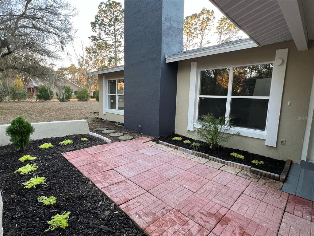 A patio with red pavers sits beside a house with a dark gray chimney — 4850 N LADYBUG DRIVE, CRYSTAL RIVER, FL