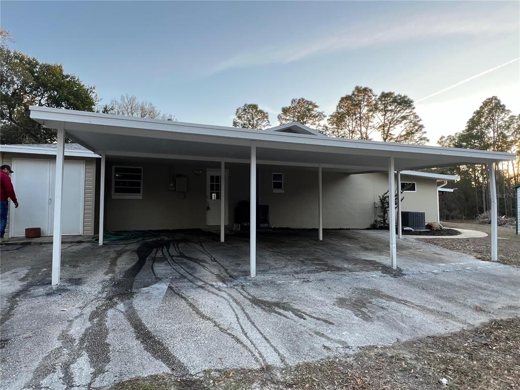 A house exterior features a large covered carport over a concrete driveway — 4850 N LADYBUG DRIVE, CRYSTAL RIVER, FL