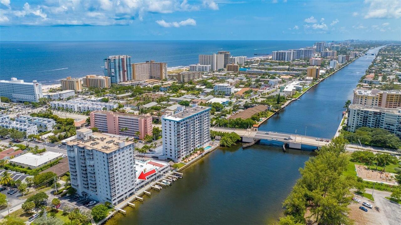 An aerial view shows a tall residential building with a red arrow pointing toward its pool deck — 1505 N Riverside Drive # 404, Pompano Beach FL 33062, POMPANO BEACH, FL