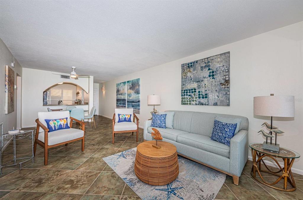 A living room features tile floors, a light blue sofa, two armchairs, and coastal decor — 6291 BAHIA DEL MAR CIRCLE UNIT 207, ST PETERSBURG, FL
