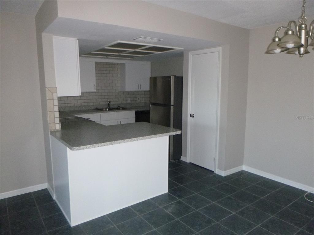 A kitchen with white cabinets, a breakfast bar, and stainless steel appliances — 4416 HIGHLAND LANE, LAKELAND, FL