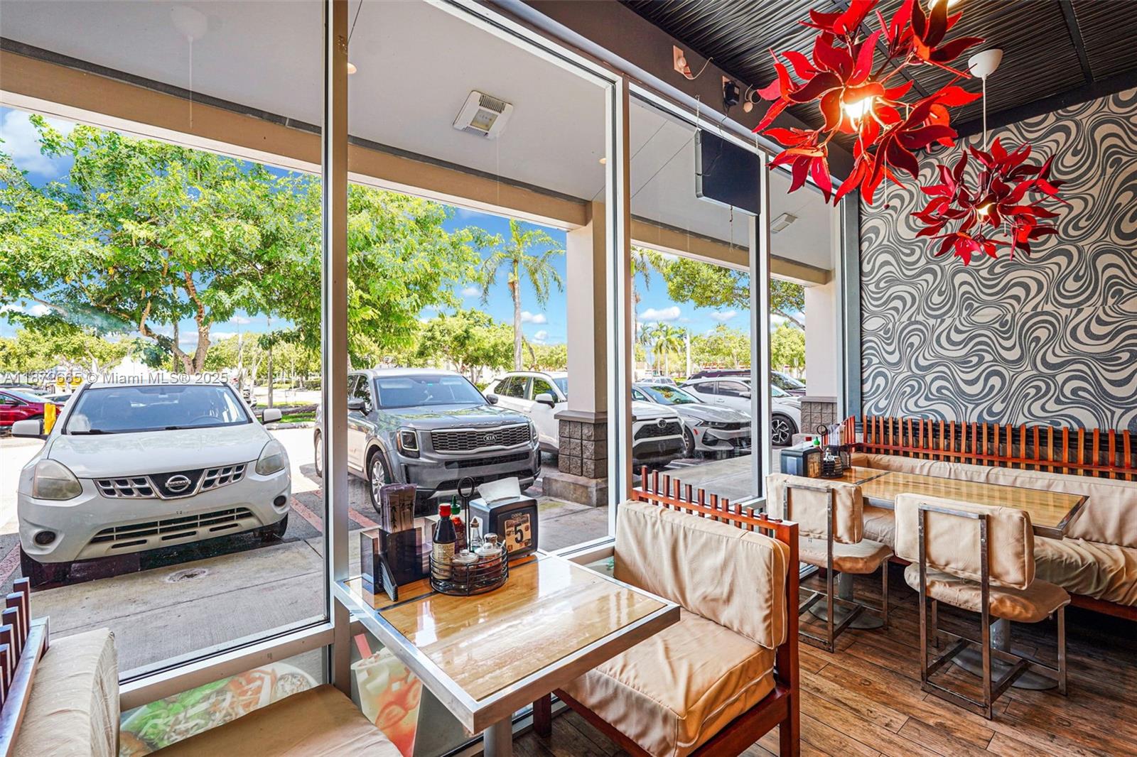 A restaurant dining area features floor-to-ceiling windows, patterned wallpaper, and red sculptural light fixtures — 16772 sw 88 st, Miami FL 33196, MIAMI, FL