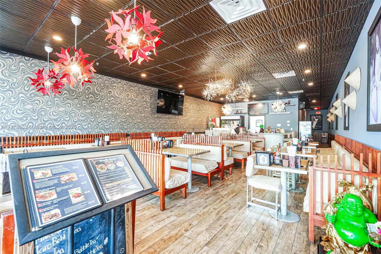 This restaurant interior features patterned wallpaper, a textured dark ceiling, and wooden booth seating — 16772 sw 88 st, Miami FL 33196, MIAMI, FL