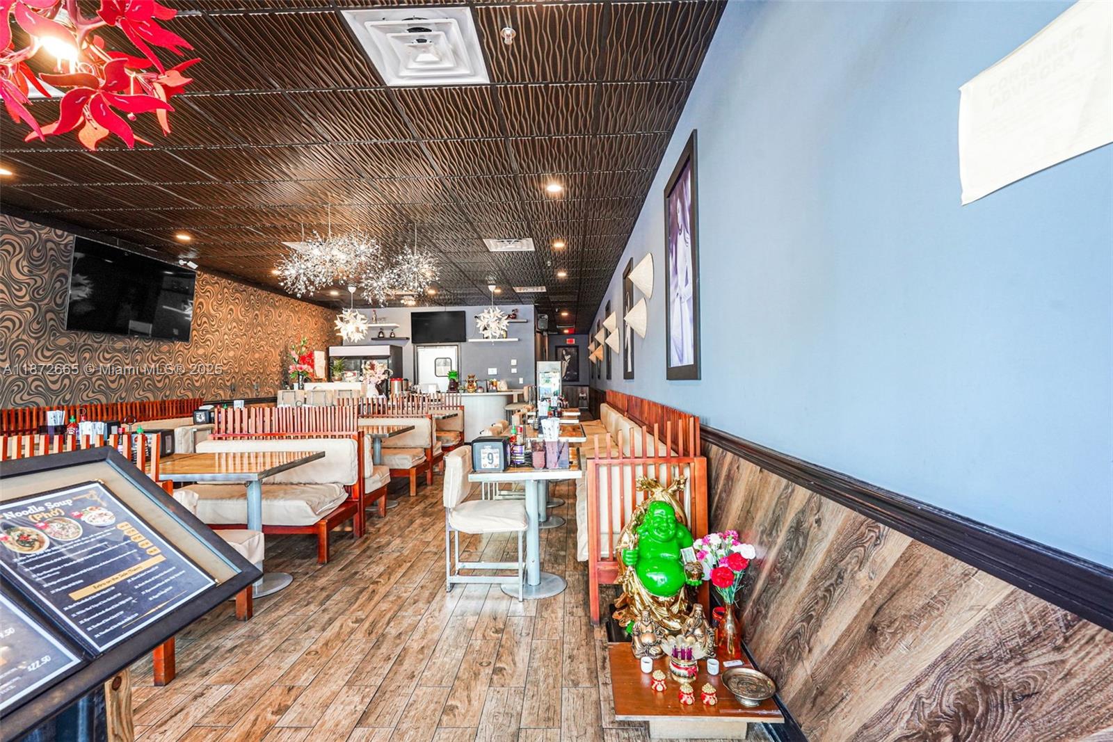 This restaurant interior features wood-look flooring, a textured dark ceiling, and a green Buddha statue — 16772 sw 88 st, Miami FL 33196, MIAMI, FL