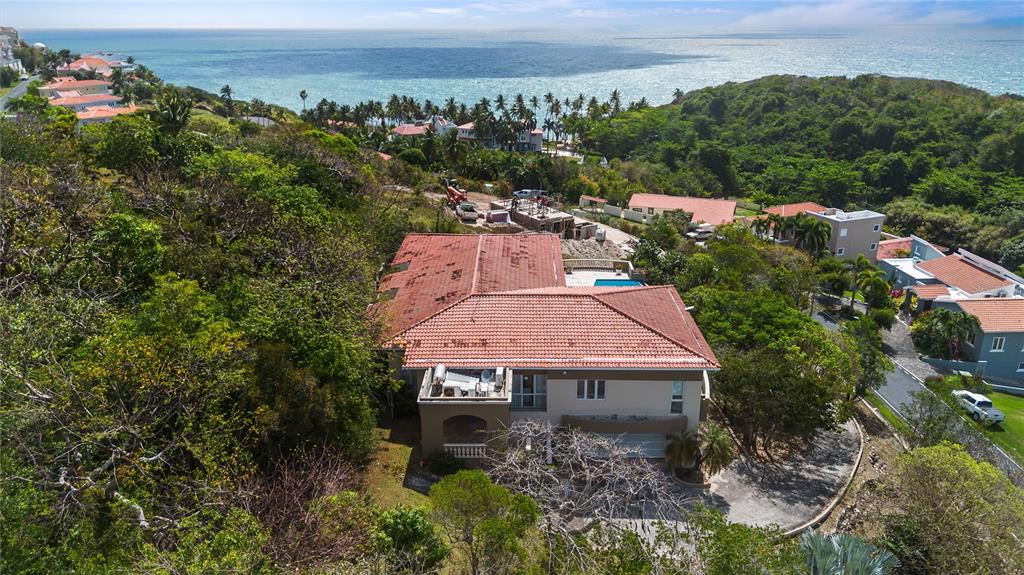 An aerial view of a multi-story house with a red tile roof near the ocean — 9 SHELL CASTLE, HUMACAO, PR