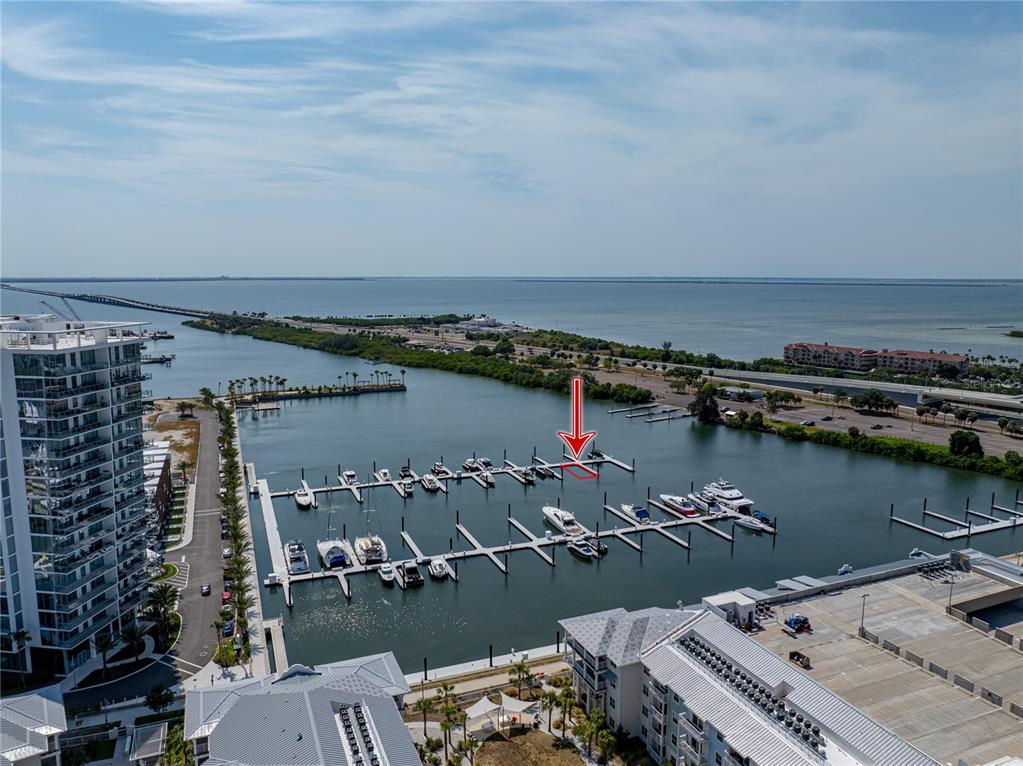 An aerial view shows a marina with multiple boat slips and a red arrow pointing to one — 5120 MARINA WAY UNIT D-E-16, TAMPA, FL