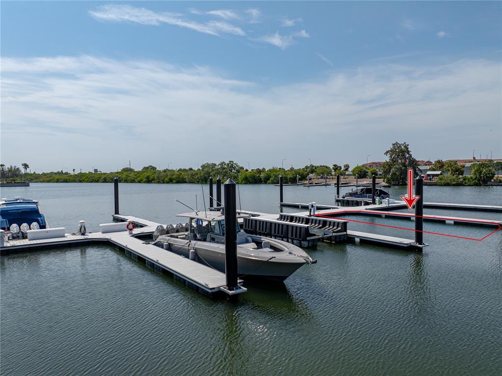 A boat is docked at a marina with multiple floating piers under a blue sky — 5120 MARINA WAY UNIT D-E-16, TAMPA, FL
