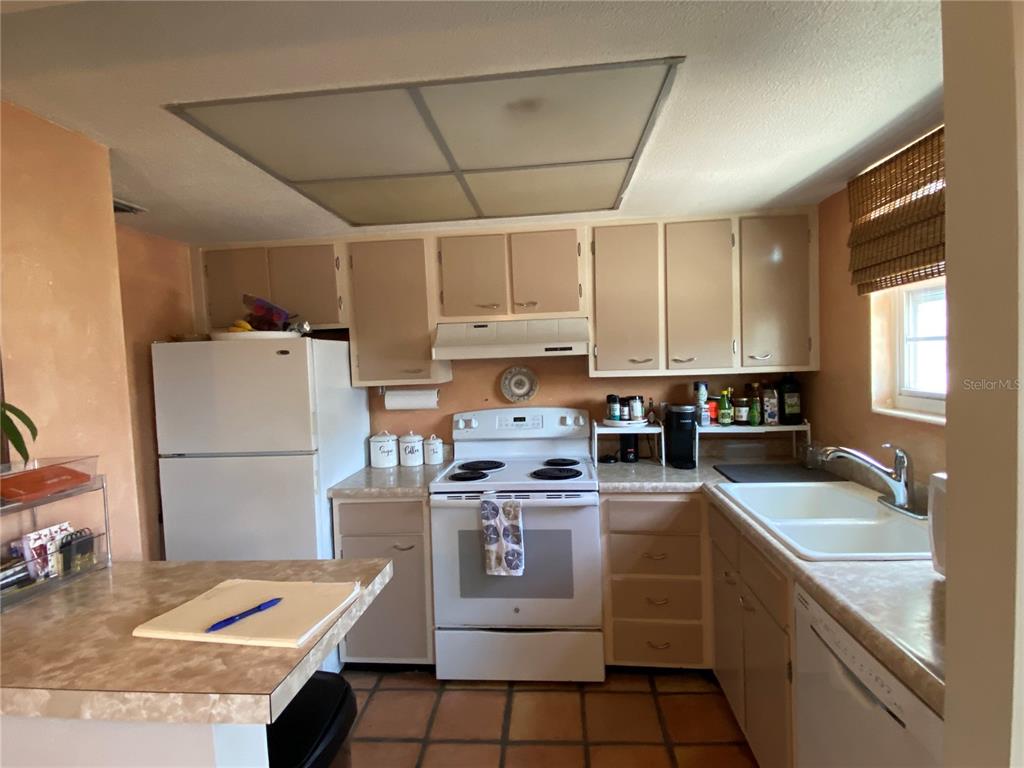 A kitchen features beige cabinets, white appliances, a tiled floor, and a laminate countertop — 1500 GAY ROAD UNIT 4D, WINTER PARK, FL