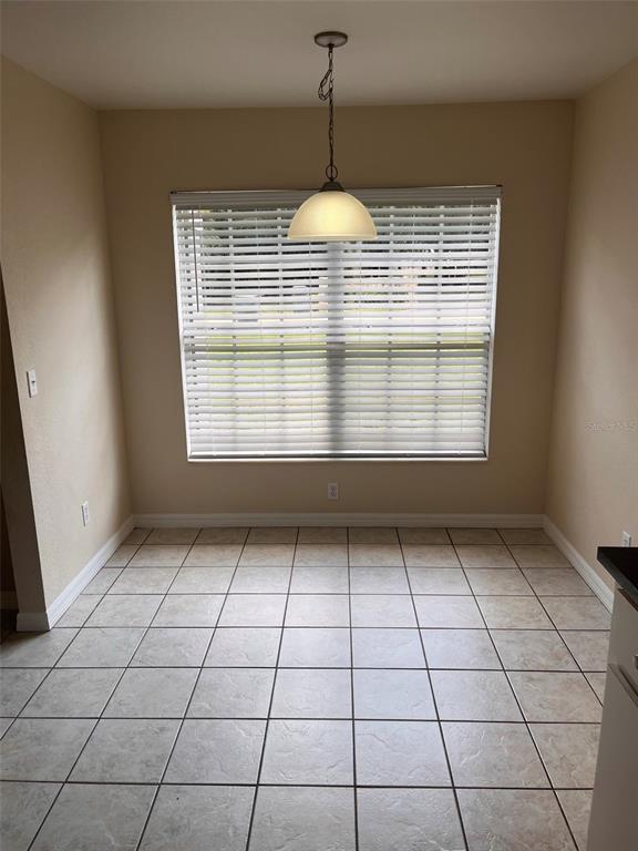 A dining area features beige walls, light-colored tile flooring, and a single pendant light fixture — 2005 N LAKE ELOISE DRIVE, WINTER HAVEN, FL