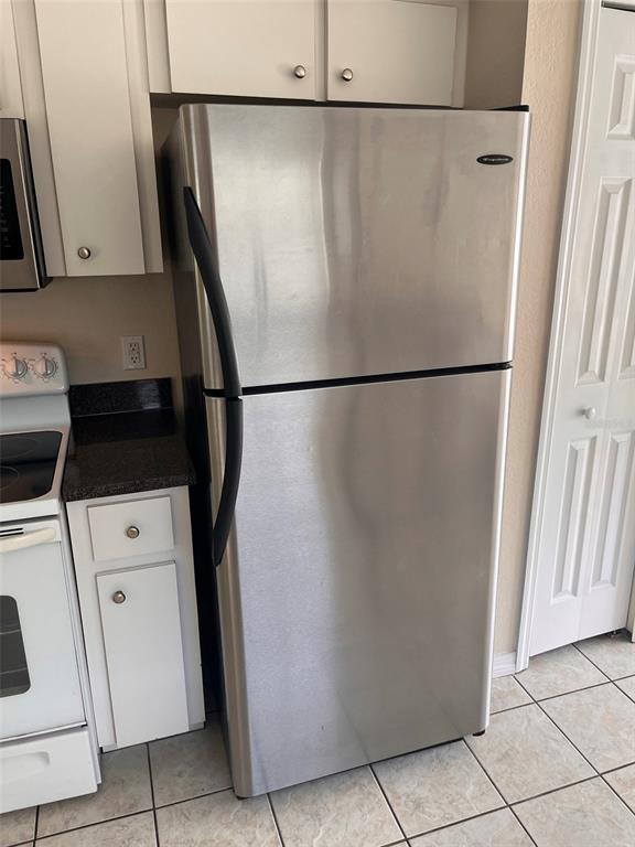 A stainless steel refrigerator stands in a kitchen next to a white stove and cabinets — 2005 N LAKE ELOISE DRIVE, WINTER HAVEN, FL