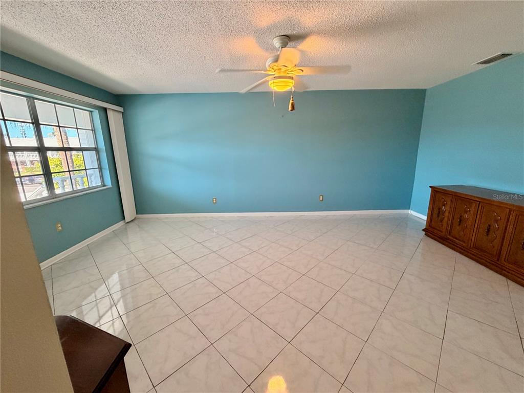A room with light blue walls, white tile flooring, and a ceiling fan — 4747 AZALEA DRIVE UNIT 231, NEW PORT RICHEY, FL