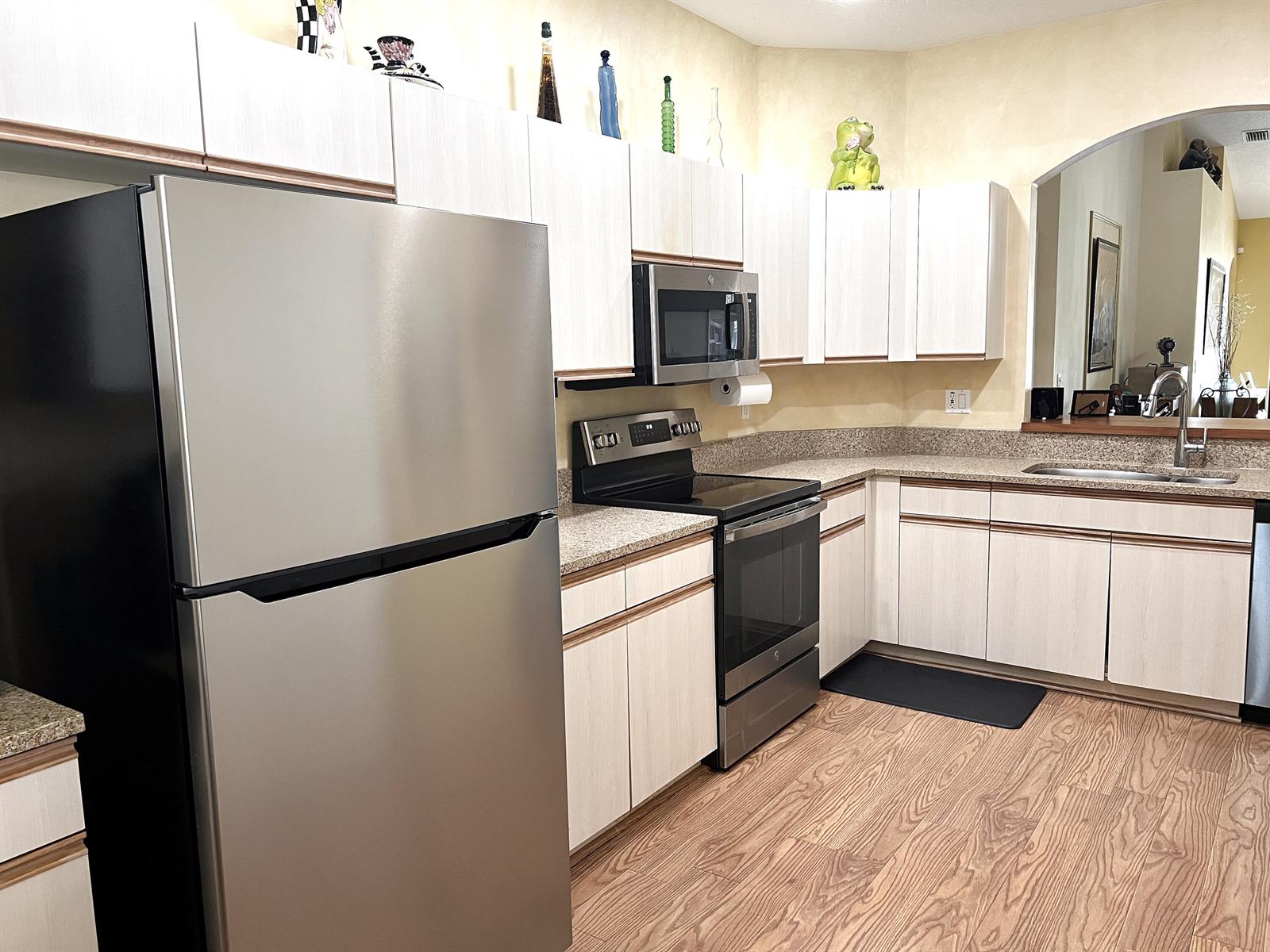 A kitchen features light wood cabinets, stainless steel appliances, and speckled granite countertops — 9624 Crescent View Drive N, Boynton Beach FL 33437, BOYNTON BEACH, FL