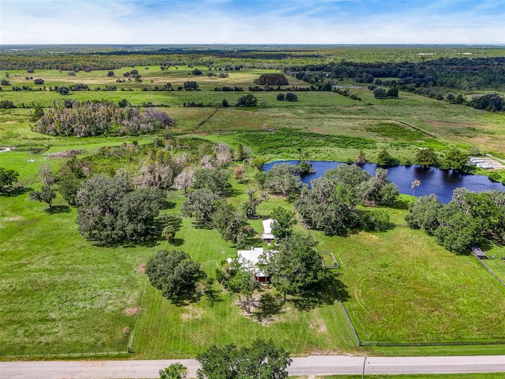 An aerial view shows a house and outbuilding on a large, grassy rural property — 350 S 5TH STREET, ORLANDO, FL