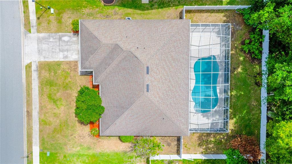 A swimming pool with a screened enclosure and string lights in a backyard — 707 POWDER HORN ROW, LAKELAND, FL