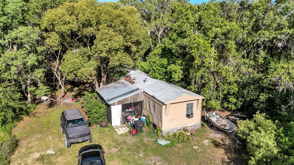 An aerial view shows a mobile home with a metal roof surrounded by dense trees — 2220 ELLIE ROAD UNIT B, AUBURNDALE, FL