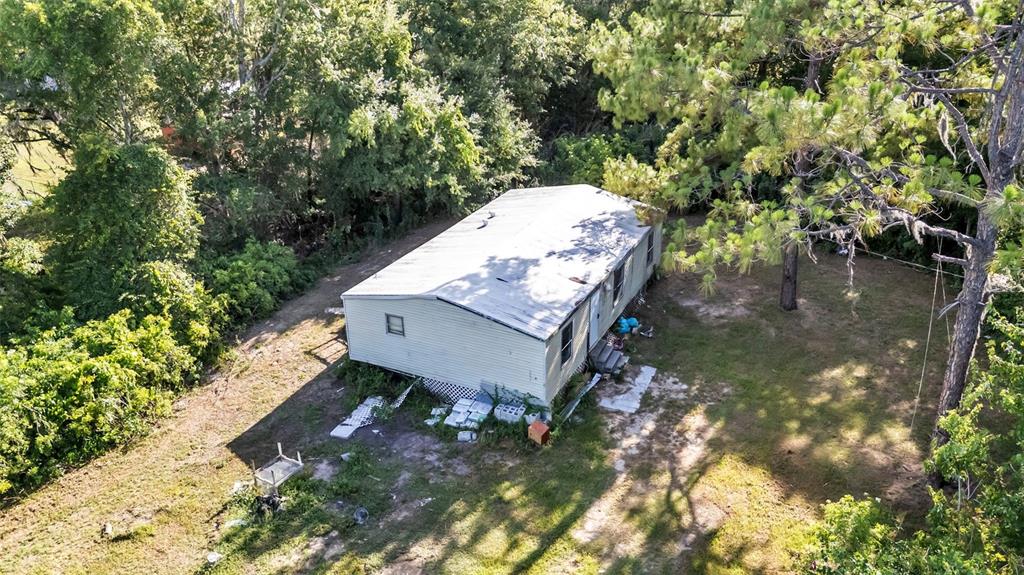 An aerial view shows a single-story manufactured home surrounded by trees and a grassy yard — 2220 ELLIE ROAD UNIT B, AUBURNDALE, FL