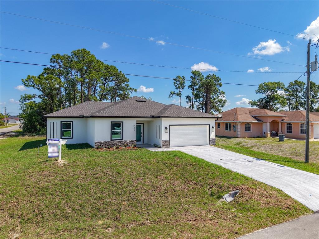 A newly constructed white single-story house with a two-car garage and a concrete driveway — 4018 3RD STREET W, LEHIGH ACRES, FL