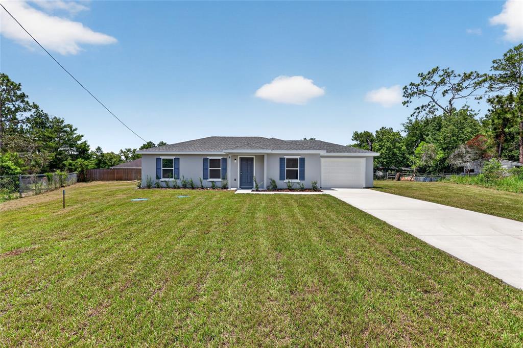 A single-story house with a gray exterior, blue shutters, and a concrete driveway — 8 OAK CIRCLE TRACE, OCALA, FL
