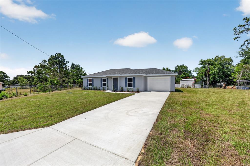 A single-story house with a gray exterior, a concrete driveway, and a two-car garage — 8 OAK CIRCLE TRACE, OCALA, FL