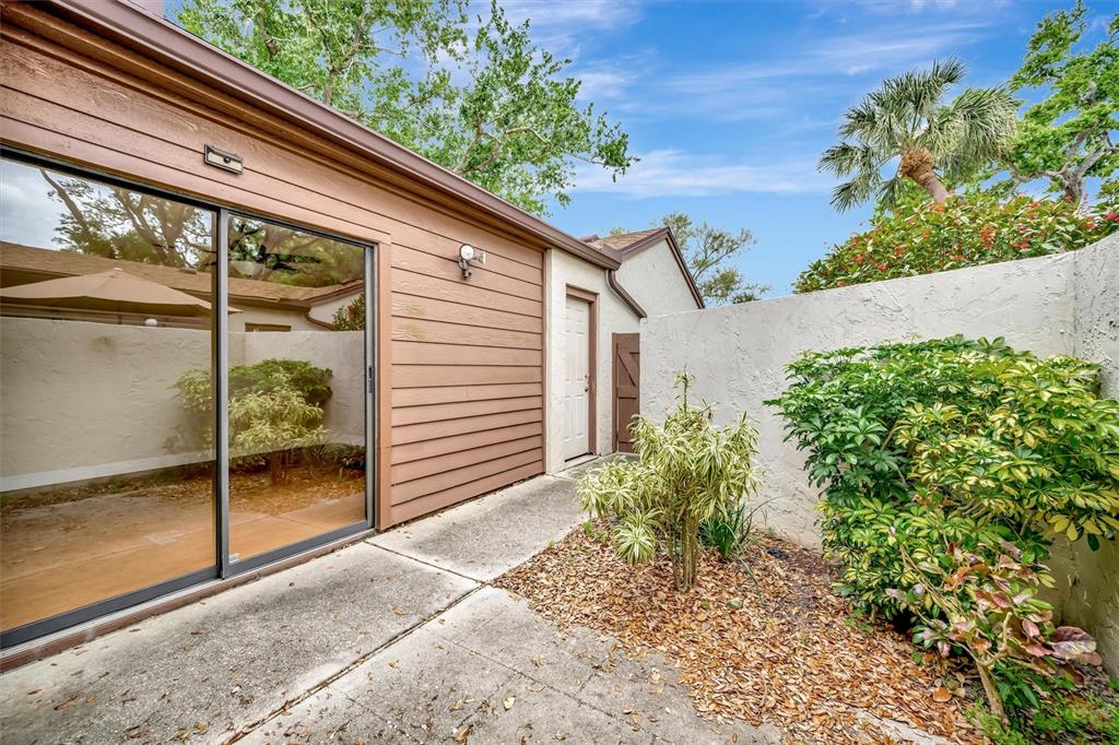 A patio with a sliding glass door, a small door, and a concrete floor — 2925 PARK LAKE DRIVE UNIT 12, BRADENTON, FL