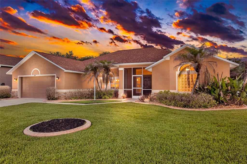 A single-story tan stucco house with a two-car garage and a screened front entryway — 1714 CREEKWATER BOULEVARD, PORT ORANGE, FL