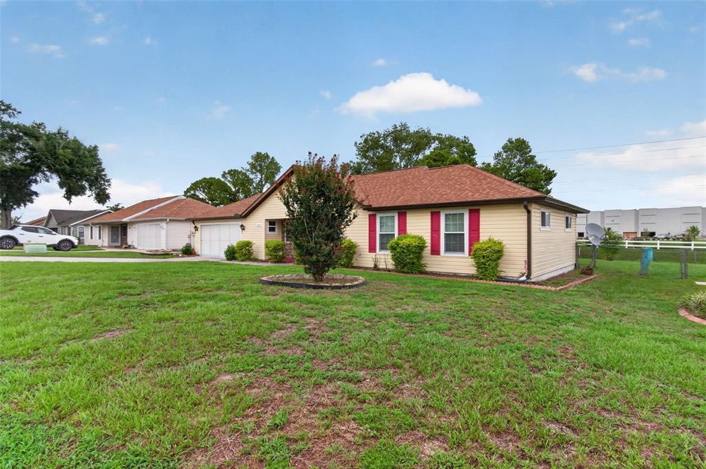 A single-story house with yellow siding, red shutters, and a brown shingled roof — 3341 NW 44TH COURT, OCALA, FL
