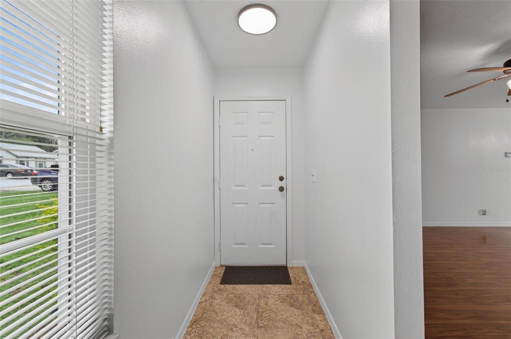 An entryway features a white door, tiled floor, and a window with blinds — 3341 NW 44TH COURT, OCALA, FL