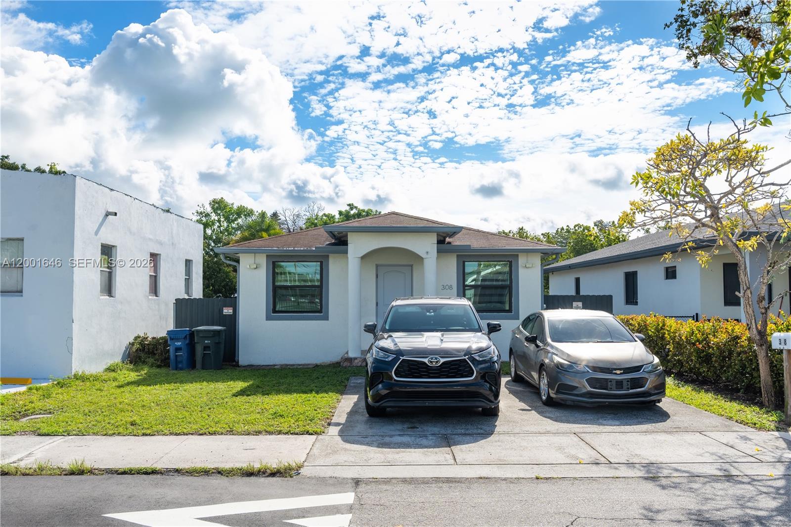 A bright dining room features a glass table, white chairs, and light wood-look flooring — 308 NW 2nd Ave, Hallandale Beach FL 33009, HALLANDALE BEACH, FL