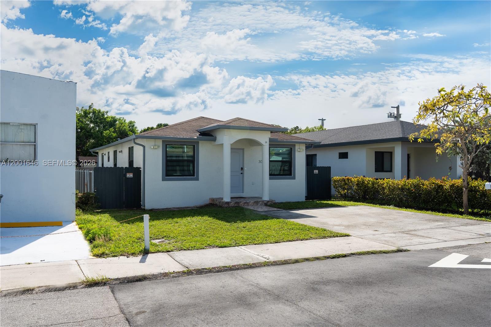 A bright, open-concept living and dining area features white cabinetry, light wood flooring, and modern furniture — 308 NW 2nd Ave, Hallandale Beach FL 33009, HALLANDALE BEACH, FL