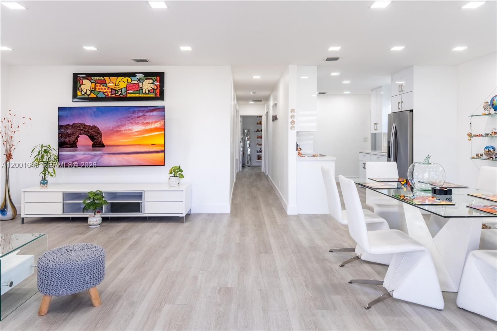 A modern living room features a wall-mounted television, white media console, and glass coffee table — 308 NW 2nd Ave, Hallandale Beach FL 33009, HALLANDALE BEACH, FL
