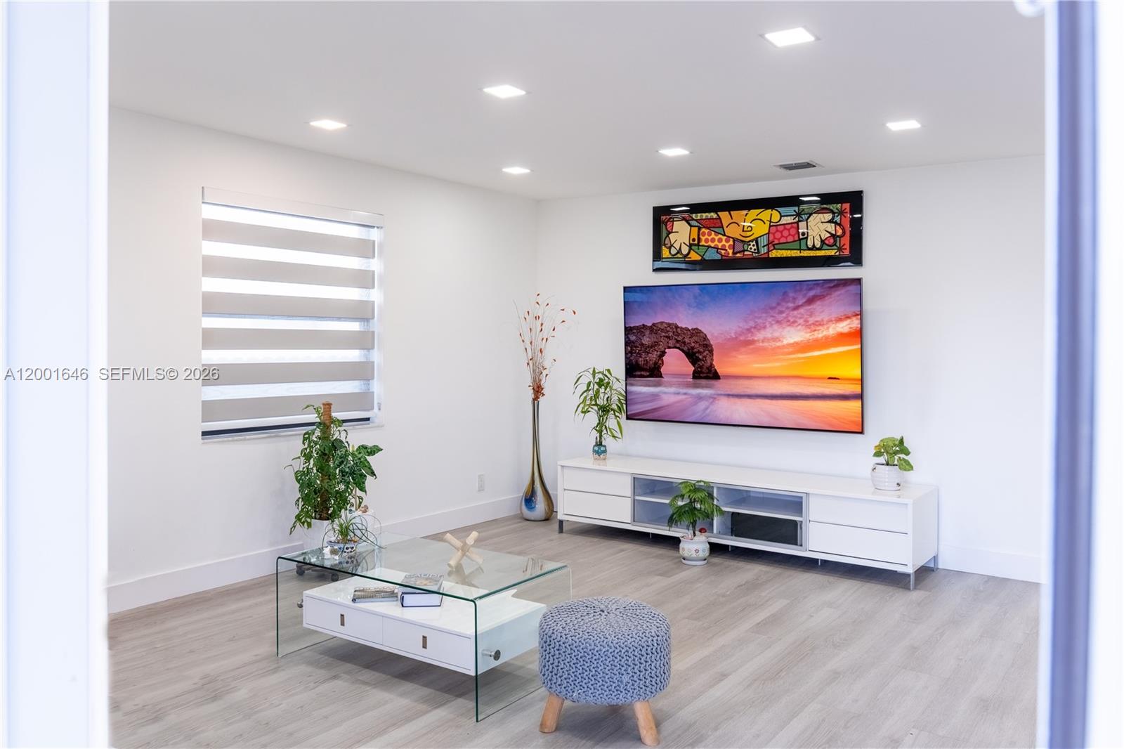 A dining room features a glass table, white chairs, light wood flooring, and large windows — 308 NW 2nd Ave, Hallandale Beach FL 33009, HALLANDALE BEACH, FL