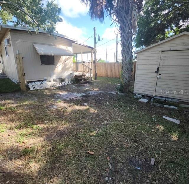 A backyard view shows a light-colored house, a detached shed, and a tall palm tree — 5609 LEISURE LANE, NEW PORT RICHEY, FL