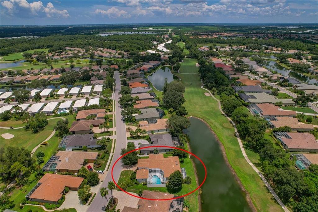 An aerial view of a suburban house with a screened-in pool beside a golf course — 5221 88TH STREET E, BRADENTON, FL