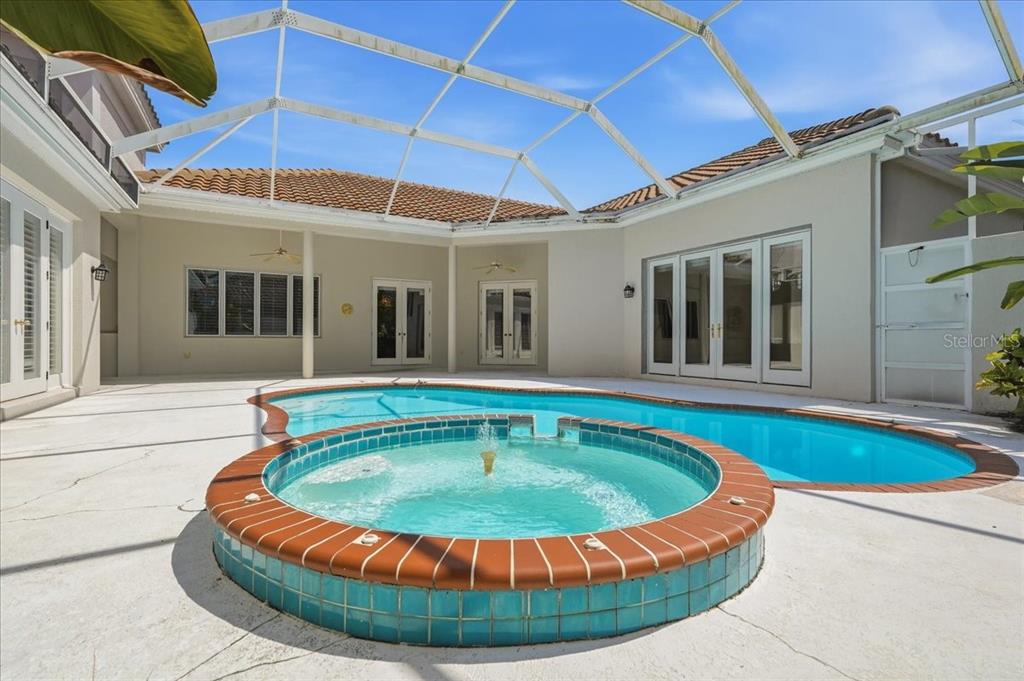A screened-in patio features a swimming pool and a raised circular spa with a fountain — 5221 88TH STREET E, BRADENTON, FL