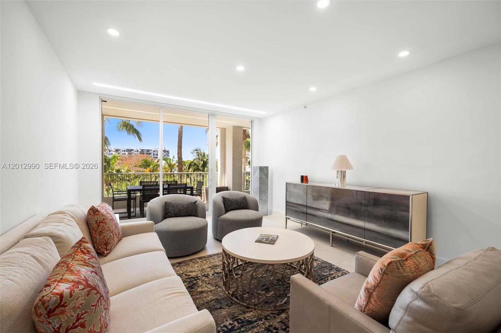 A modern living room features a sofa, two armchairs, a coffee table, and a balcony — 701 Crandon Blvd # 401, Key Biscayne FL 33149, KEY BISCAYNE, FL