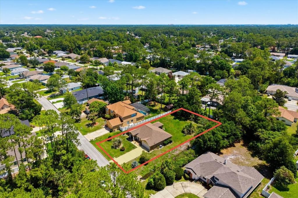 An aerial view shows a single-story house with a brown roof on a large lot — 34 BREWSTER LANE, PALM COAST, FL