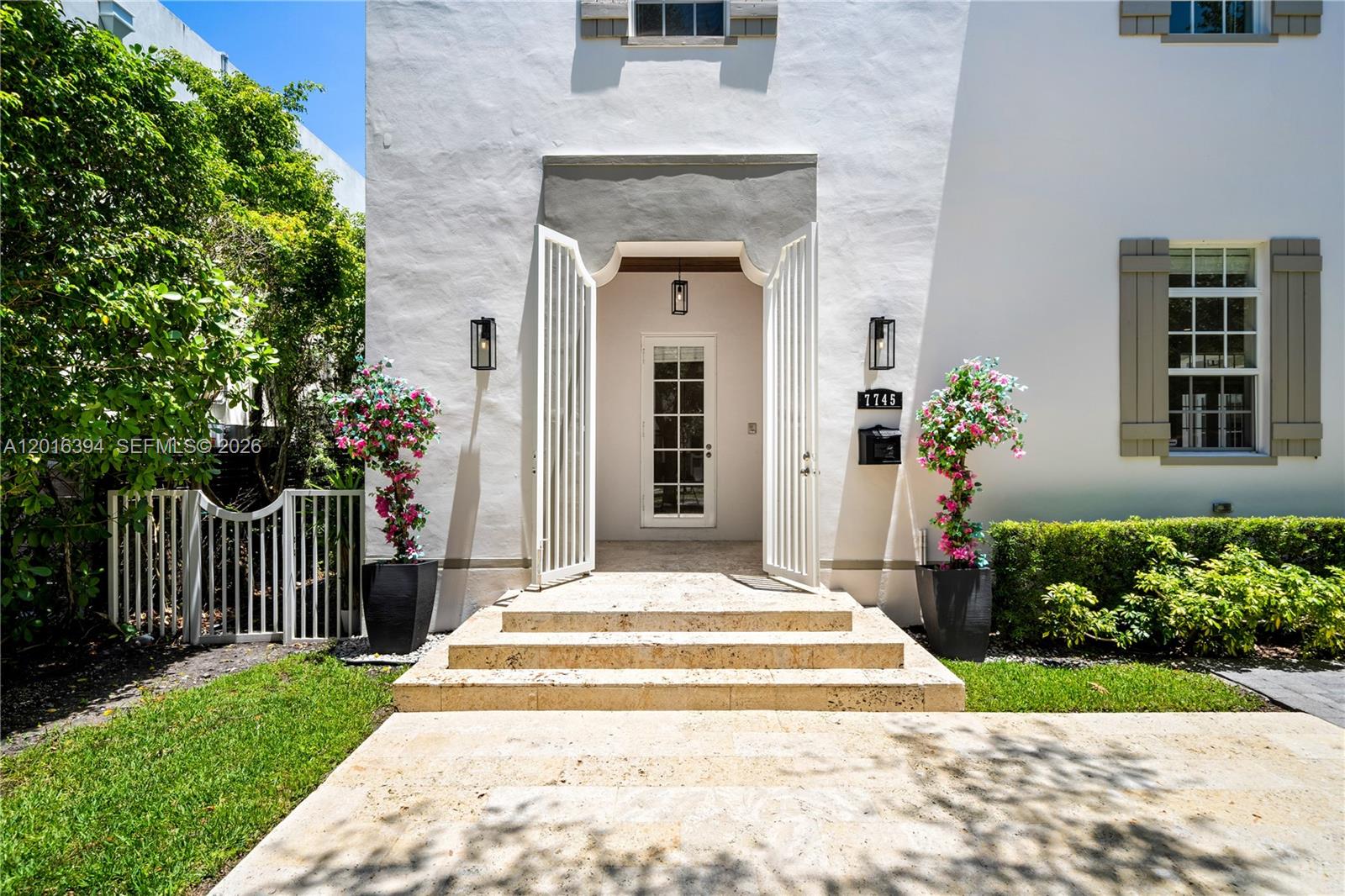 The exterior of a white house features a stone entryway with steps and double gates — 7745 SW 54th Ave, Miami FL 33143, MIAMI, FL