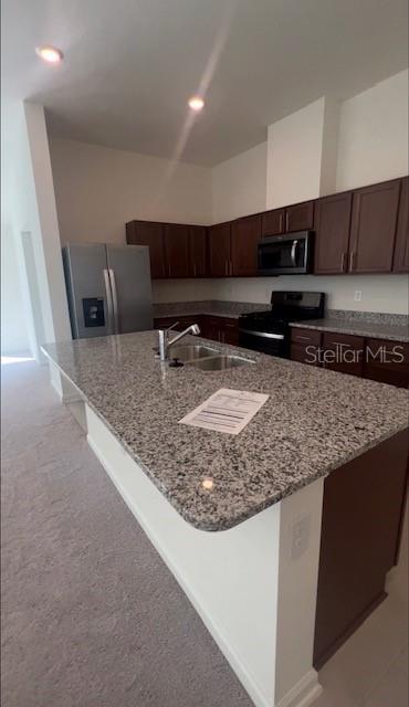 A kitchen features dark wood cabinets, granite countertops, stainless steel appliances, and a large island — 37 WILLOW STREET, PALM COAST, FL