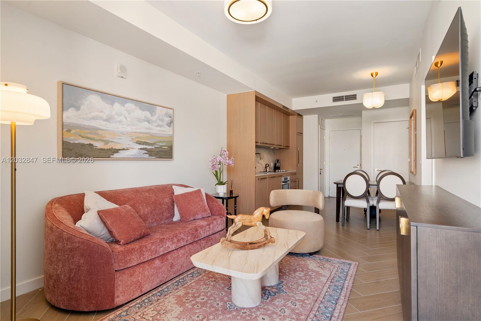 A living room features a pink sofa, a stone coffee table, and an adjacent kitchen — 2700 NW 2ND AVE # 728, Miami FL 33127, MIAMI, FL